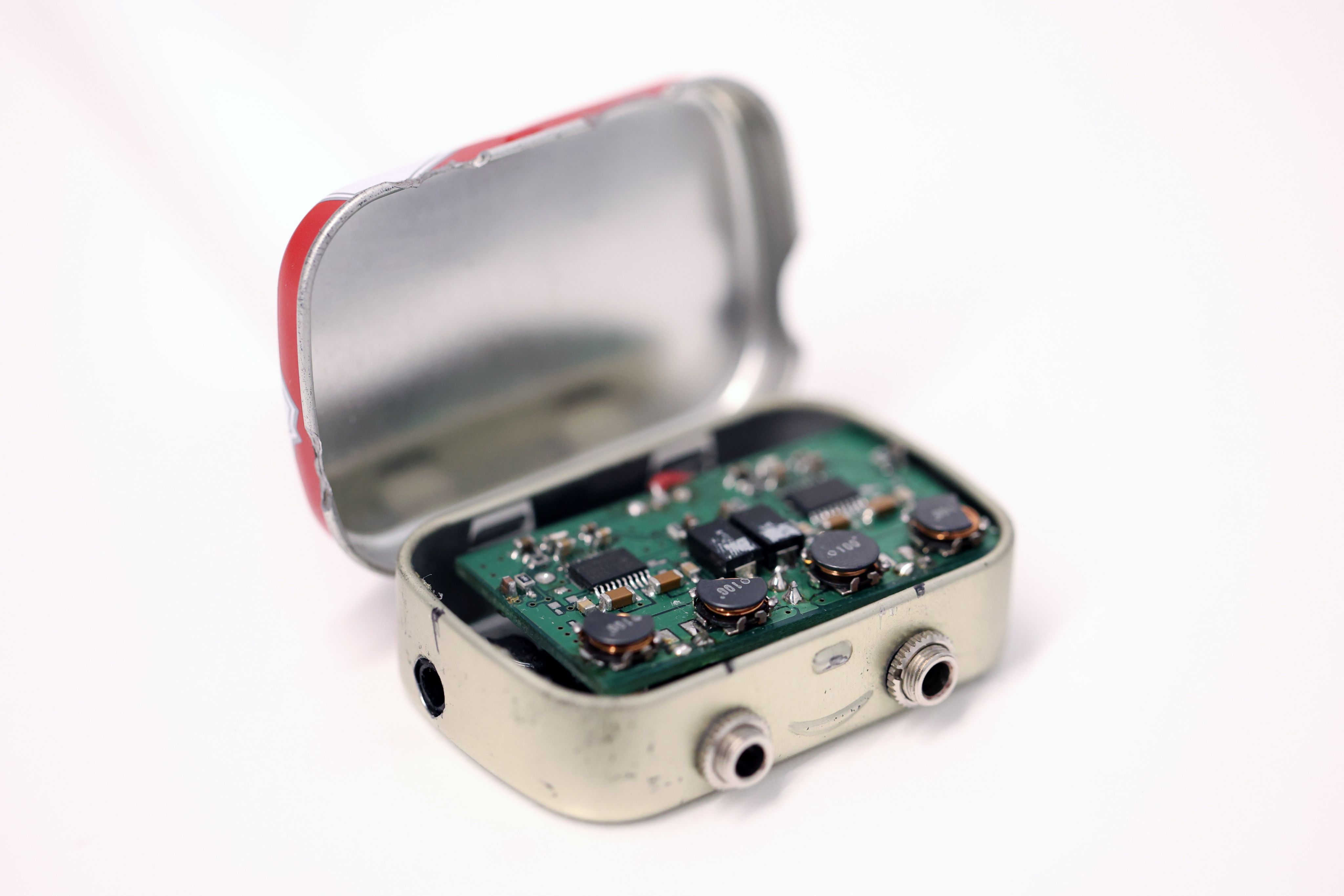 Open Altoids tin revealing the prototype amplifier circuit.
